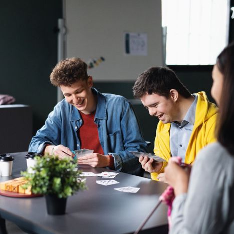 Someone with a disability playing cards with friends